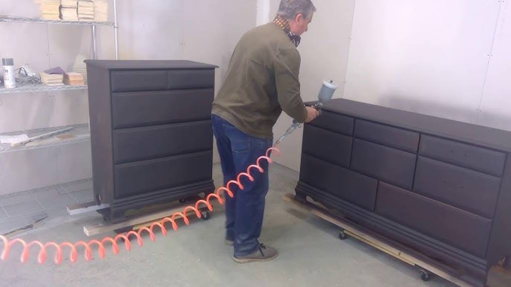 DIYer painting a dresser with Dixie Belle Chalk Mineral Paint using an HVLP spray gun.